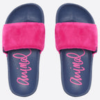 A pair of slide sandals with navy blue footbeds, bright pink faux-fur straps, and pink script branding on the footbeds