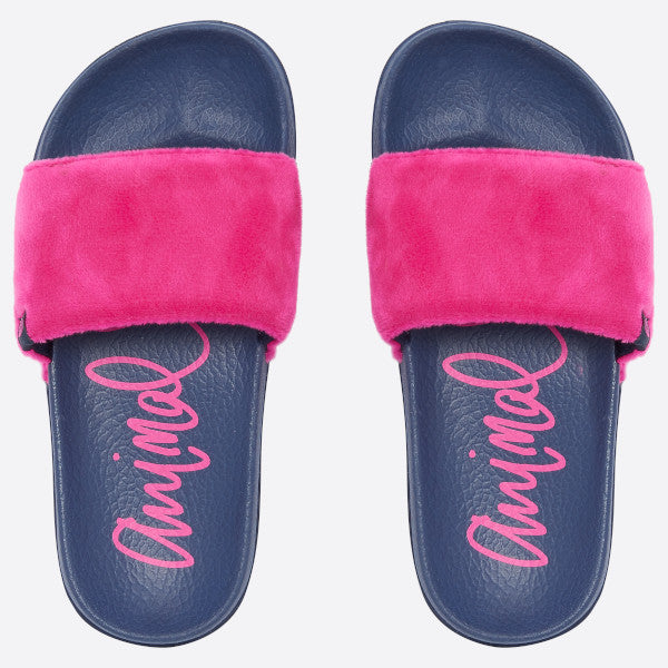 A pair of slide sandals with navy blue footbeds, bright pink faux-fur straps, and pink script branding on the footbeds