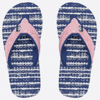 A pair of flip-flops with navy blue and white wavy patterned soles and glittery pink straps